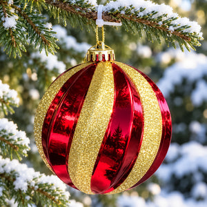 Large red Christmas bauble with curved gold glitter stripes hanging from an outdoor Christmas tree.