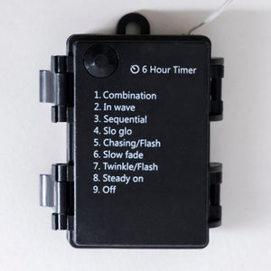 A black rectangular electronic device with a hinged cover, featuring a printed list of light modulation modes including Combination, In wave, Sequential, Slo glo, Chasing/Flash, Slow fade, Twinkle/Flash, Steady on, and Off, along with a '6 Hour Timer' label.