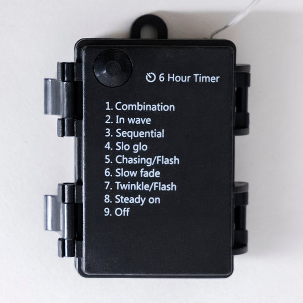 A black rectangular electronic device with a hinged cover, featuring a printed list of light modulation modes including Combination, In wave, Sequential, Slo glo, Chasing/Flash, Slow fade, Twinkle/Flash, Steady on, and Off, along with a '6 Hour Timer' label.