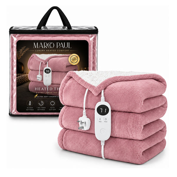 A pink heated throw blanket with a white sherpa lining, folded and shown with its white wired controller in front of its branded retail packaging box. The brand name 'MARCO PAUL' is clearly visible on the box.