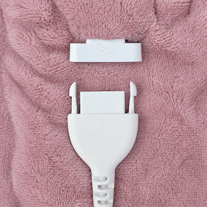 A close-up of a white plastic connector plug and matching white connector cap placed on a textured pink fabric background.
