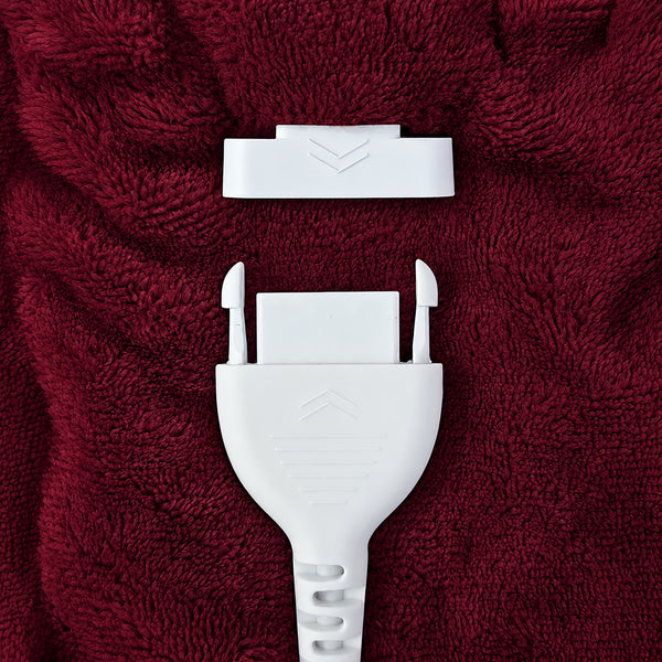 A close-up of a white plastic strap or buckle component placed on textured dark red fabric.