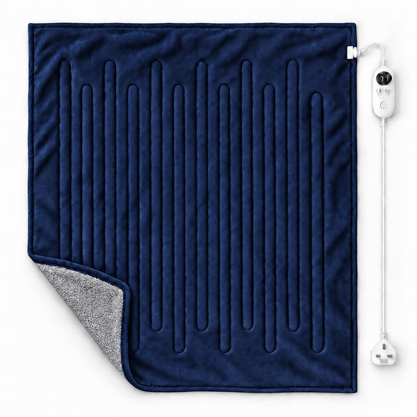 A navy blue heated blanket with vertical channel stitching, showing a gray sherpa lining on the corner, with a white wired remote control on a white background.