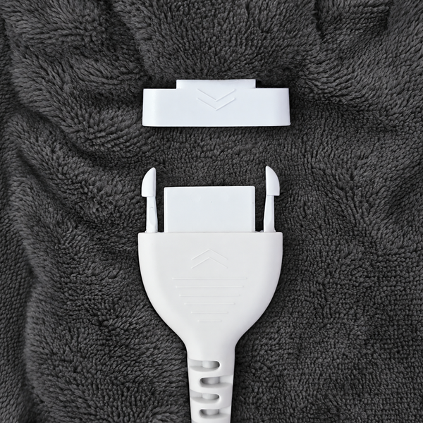 A close-up of a white plastic fastener cover and matching white plastic anchor insert placed on a dark gray textured fabric background.