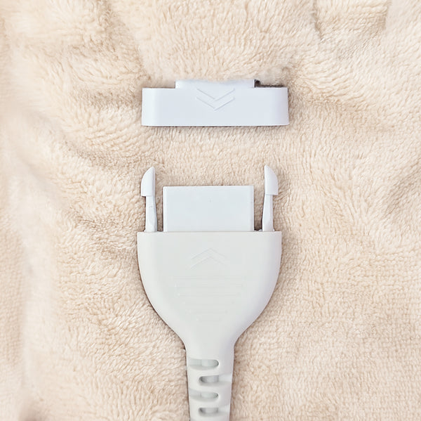 A close-up of a white plastic connector plug and matching white rectangular piece placed on a soft beige textured fabric background.