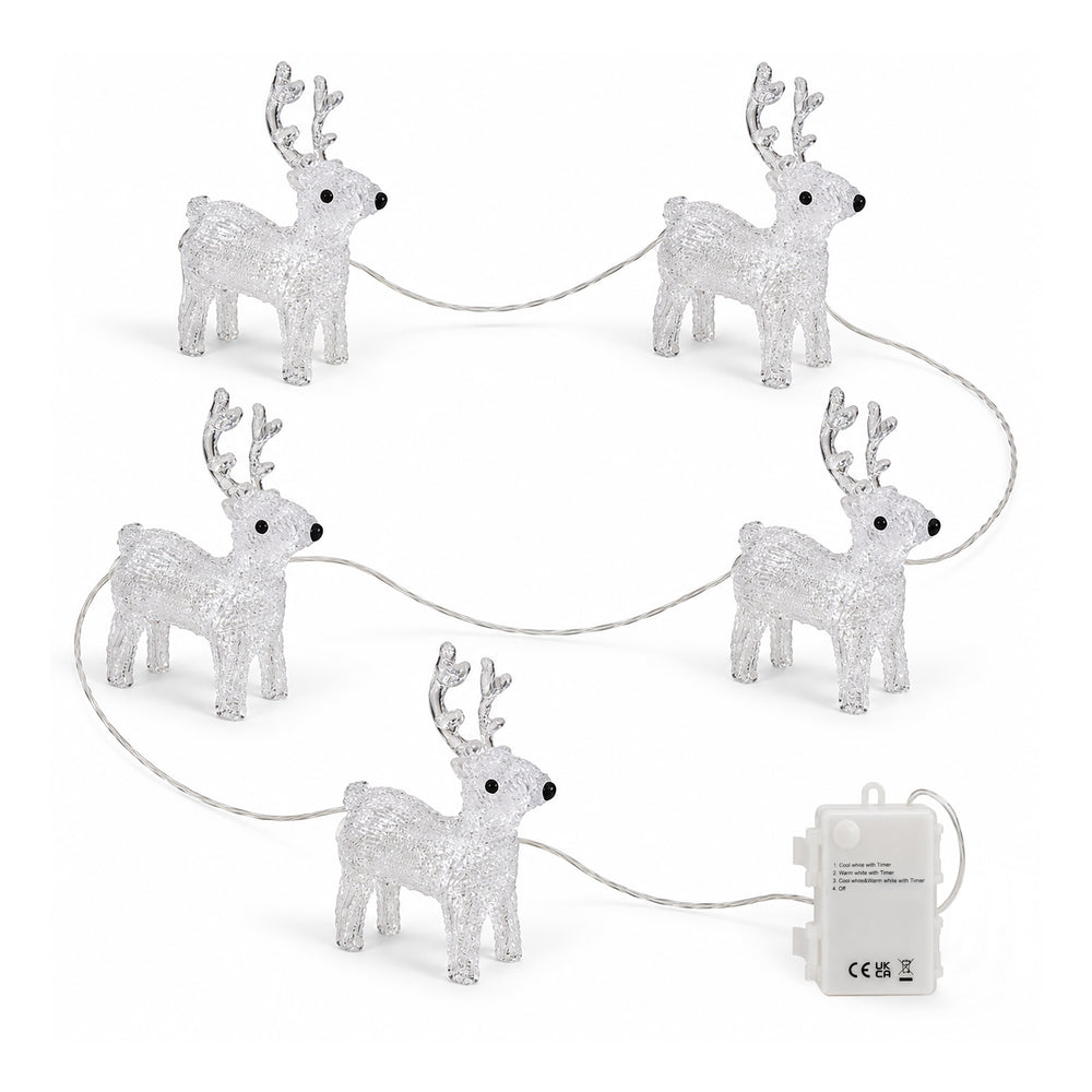 Five illuminated crystal reindeer yard lights arranged on outdoor stone steps at night, with warm lights and snowy greenery in the background.
