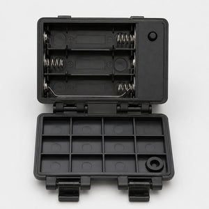 A black plastic multi-compartment battery storage case shown open, with two battery compartments inside and multiple small slots on the bottom lid, photographed on a light gray background.
