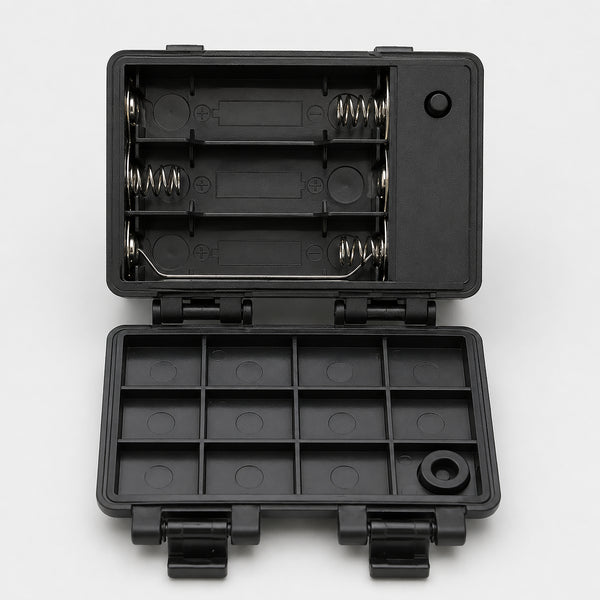 A black plastic multi-compartment battery storage case shown open, with two battery compartments inside and multiple small slots on the bottom lid, photographed on a light gray background.