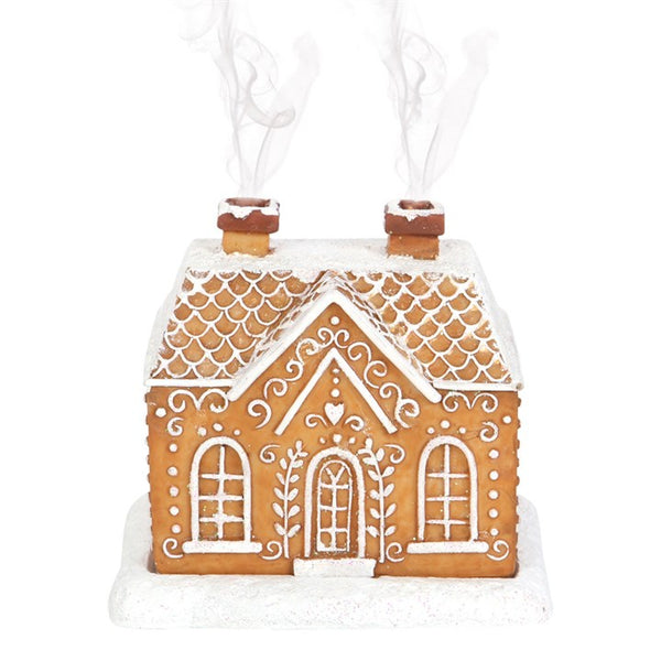 Decorative gingerbread house ornament with white icing on a white background