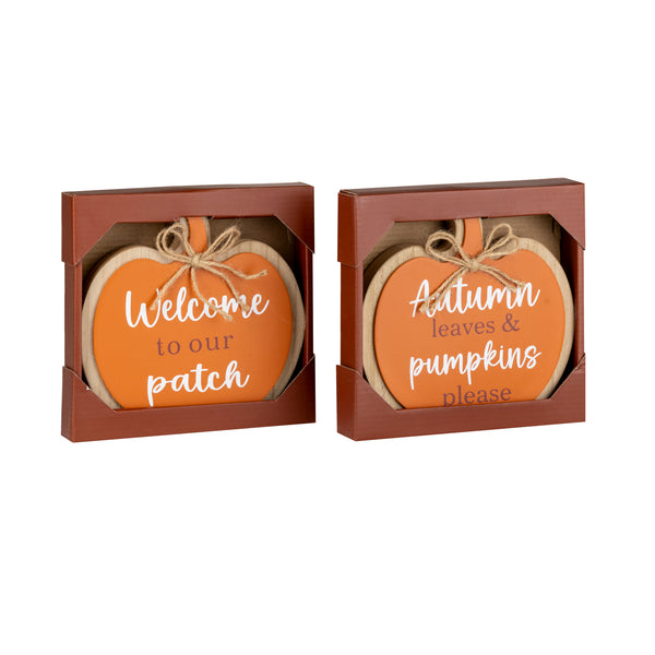 Two autumn-themed wooden sign ornaments in brown gift boxes. One sign reads 'Welcome to our patch' and the other reads 'Autumn leaves & pumpkins please' in white script on orange backgrounds.