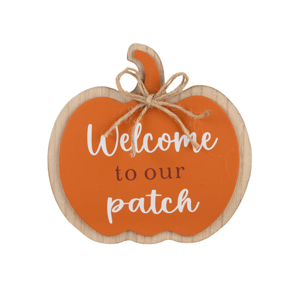 A decorative pumpkin-shaped wooden sign with an orange center, white script text reading 'Welcome to our patch,' brown lettering in the middle, and natural wood edges. A small piece of twine is tied around the top stem area.