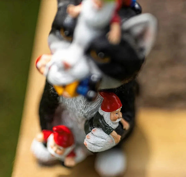 Gnome figurines with a cat on a wooden surface