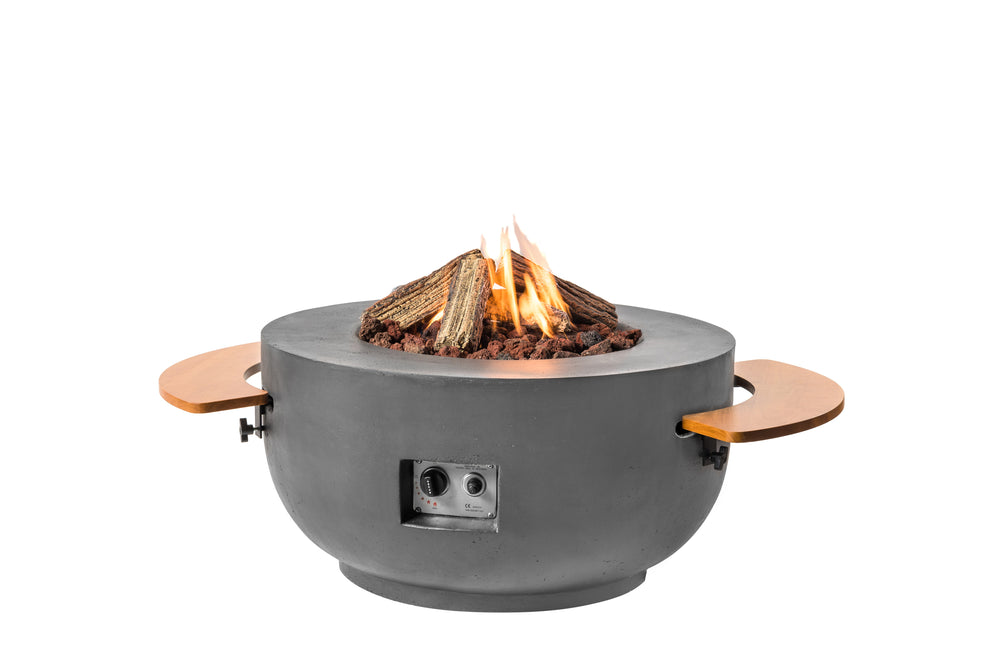 A round gray composite Cocoon fire pit with a curved structure, containing lit ceramic logs and a lava rock, designed for outdoor use.