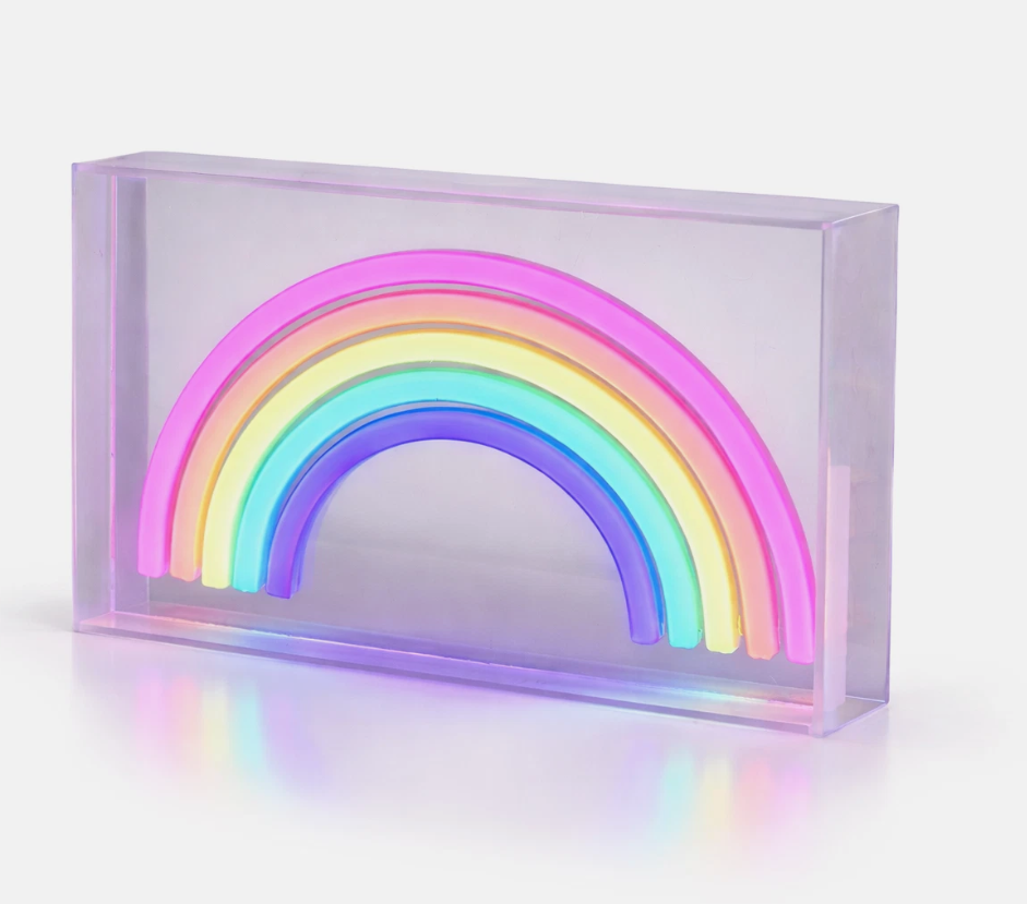 Neon rainbow light in a clear frame on a shelf with decorative items.