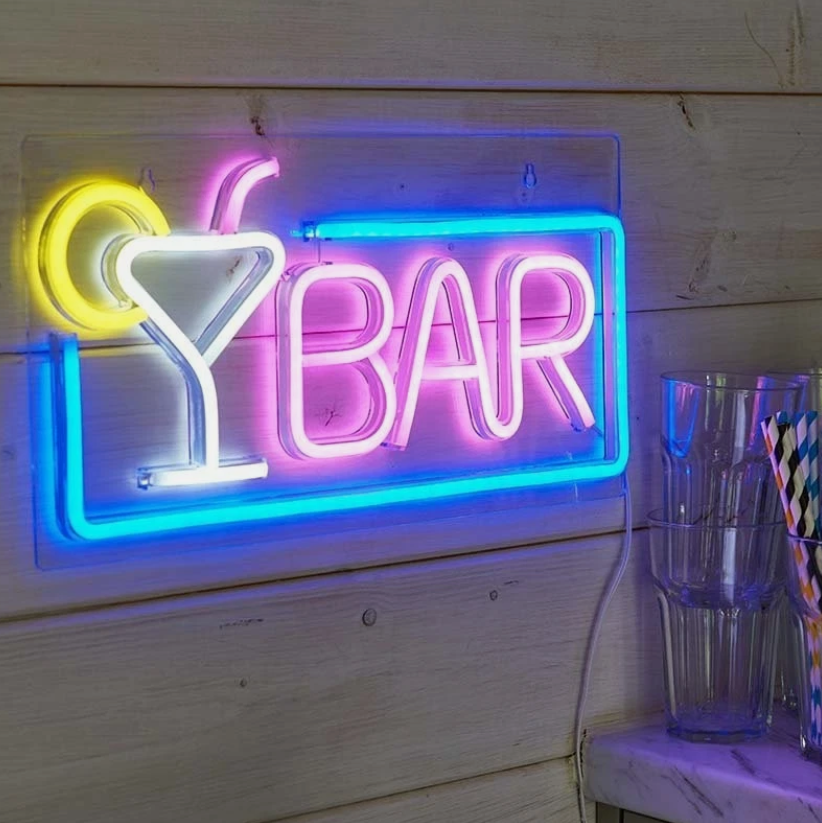 Neon sign reading 'Bar' in a bar setting with bottles and glasses.