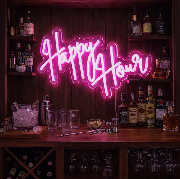 Neon sign reading 'Happy Hour' in a bar setting with bottles and glasses.