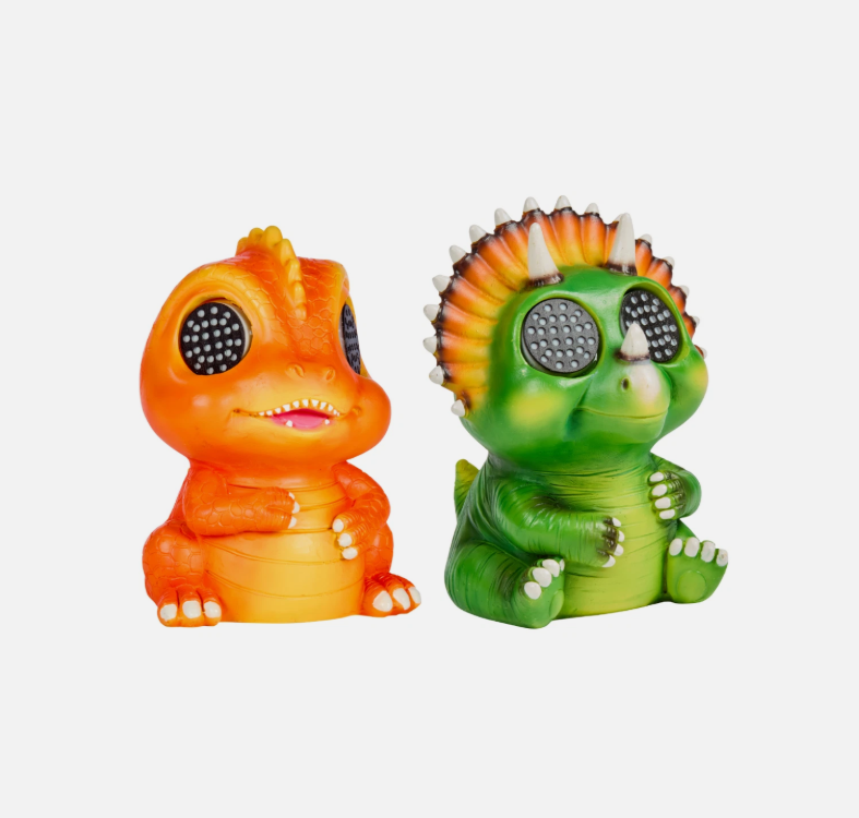 Two colorful dinosaur figurines with glowing eyes on a wooden surface.