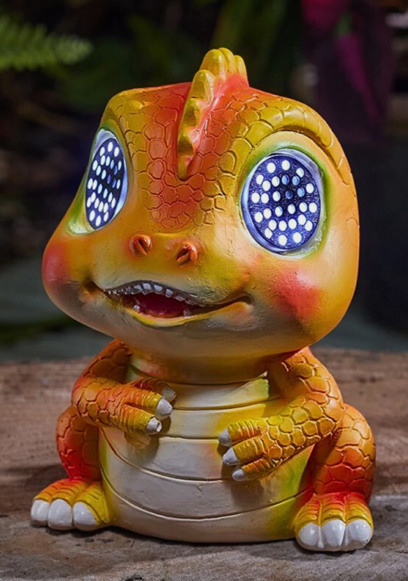 Colorful dinosaur-like creature with glowing blue eyes on a wooden surface.