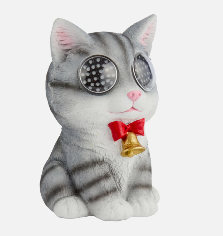Solar resin cat with eyes lit up, sitting in a garden