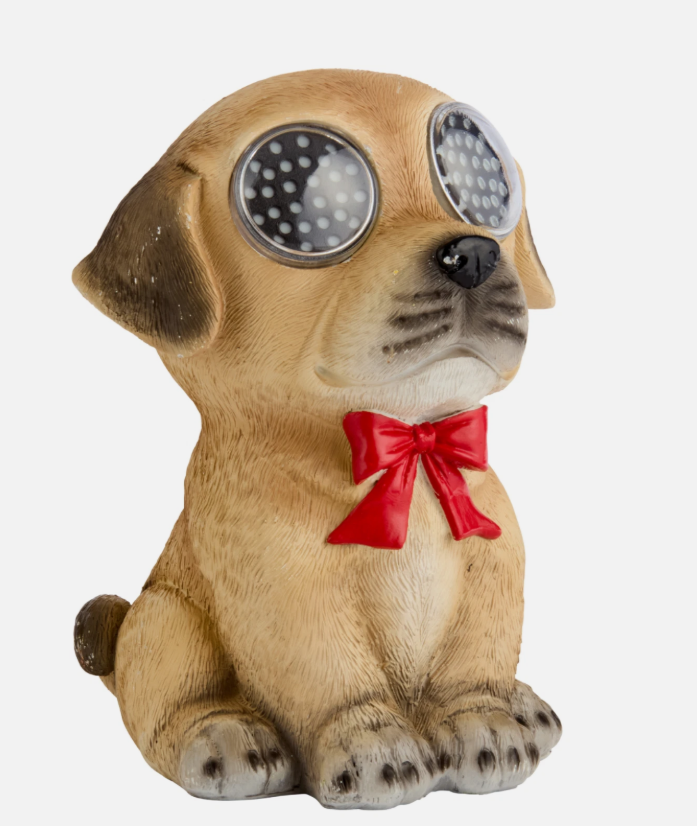 Dog figurine with LED eyes and a red bow tie on a stone surface.