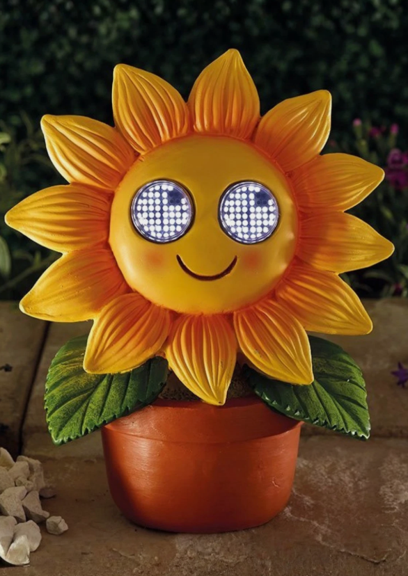 Sunflower-shaped decorative light with a smiling face on a blurred background