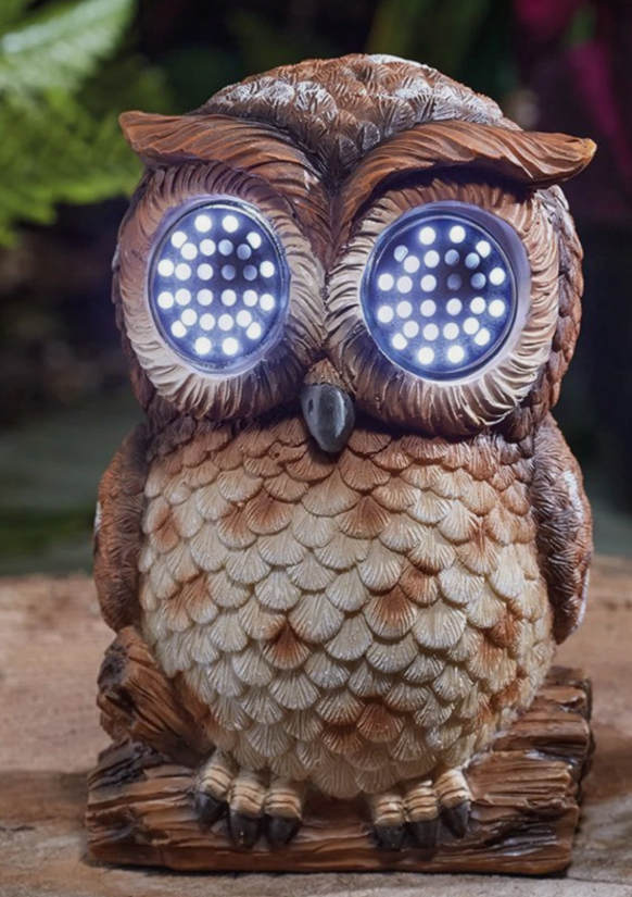 Solar-powered owl with LED eyes on a wooden surface