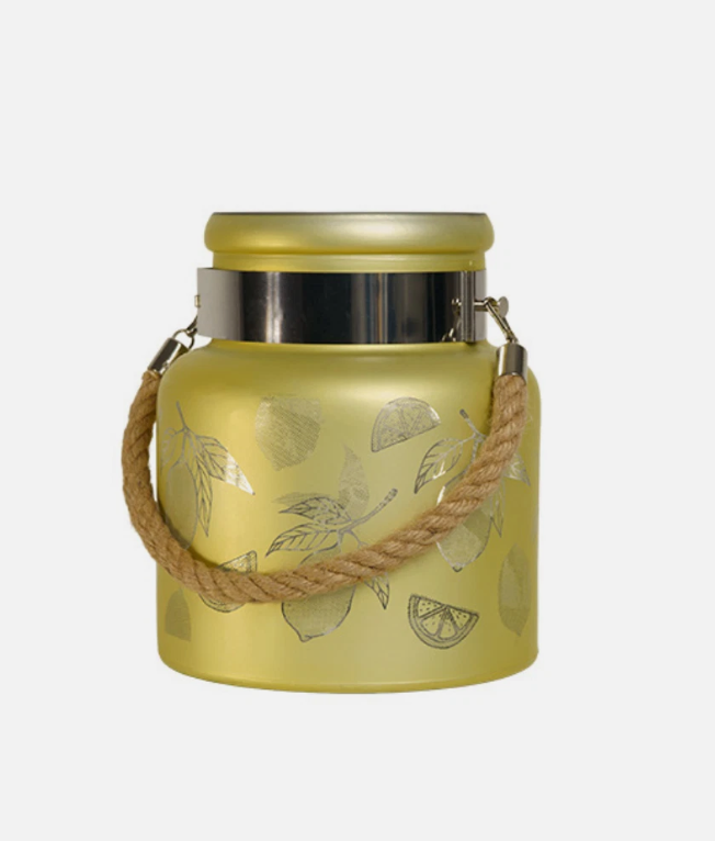 Decorative lantern with lemon designs on a stone surface outdoors