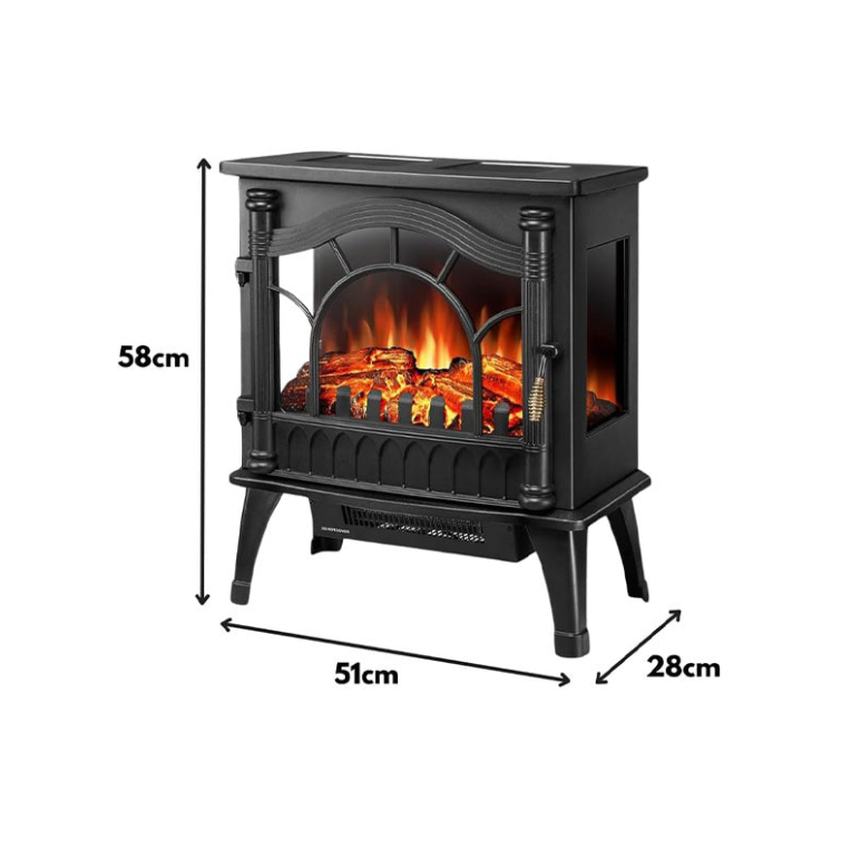 A black electric fireplace heater with a realistic flame effect, positioned in a room with a Christmas tree and decorations.