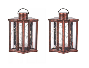Two copper lanterns with glass panels on a white background
