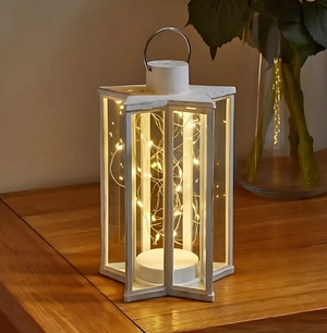 Decorative lantern with string lights on a wooden surface