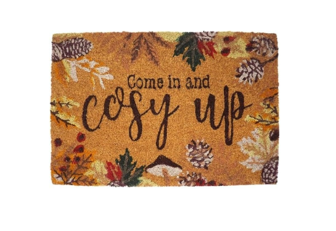 Decorative doormat with autumn theme and pumpkins on a doorstep