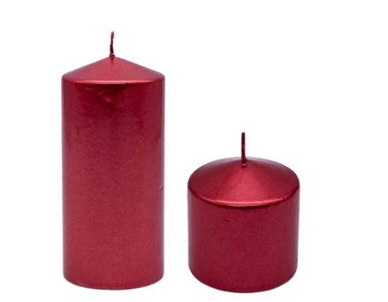 Two red candles on a table with blurred Christmas lights in the background