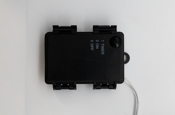 Black electronic device with buttons and a timer display on a white background