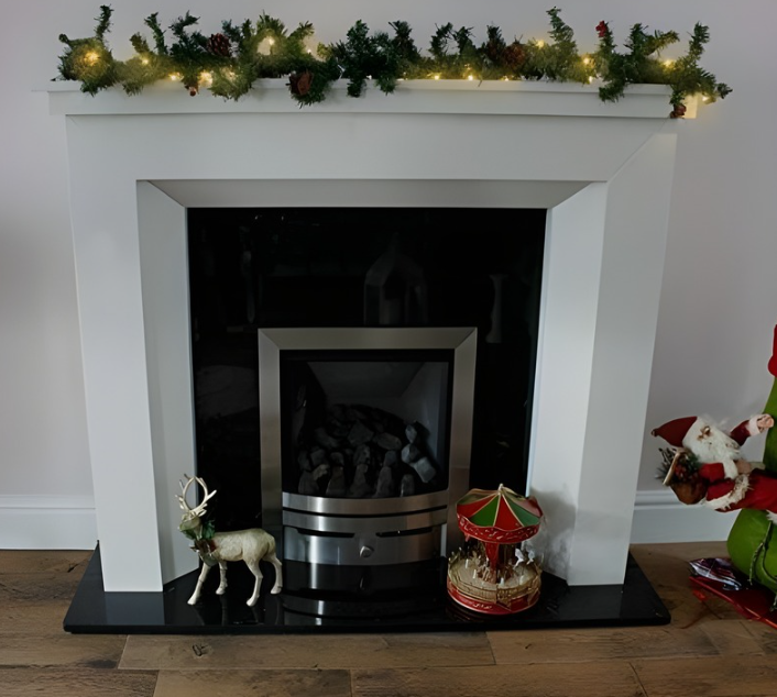 Decorative fireplace with green garland and lights, surrounded by wooden furniture and a mirror.