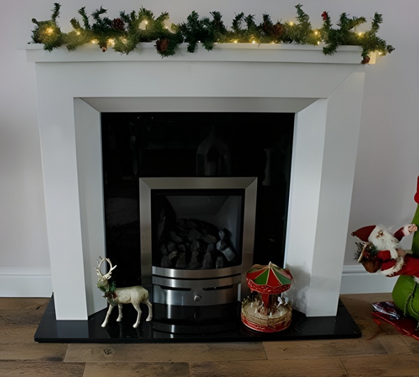 White fireplace with decorative items and a Christmas garland.
