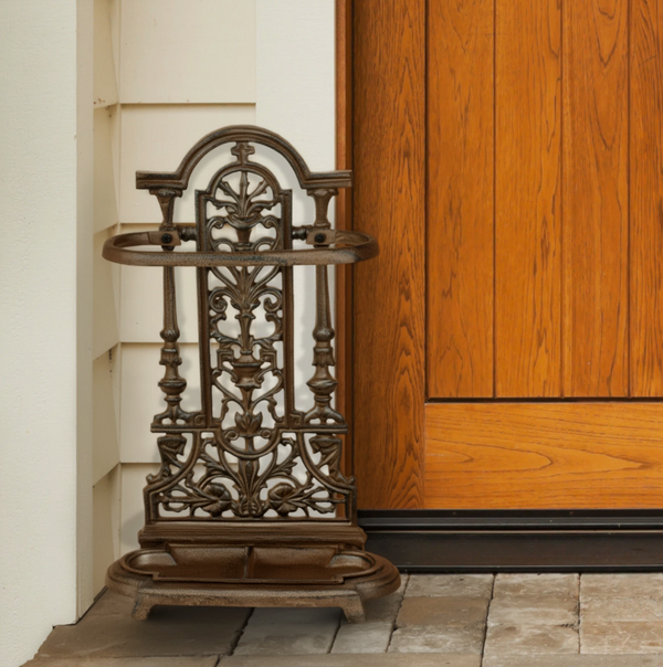 Decorative metal umbrella stand against a wooden door