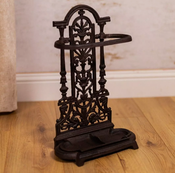 Decorative black metal stand on a wooden floor with a neutral wall background