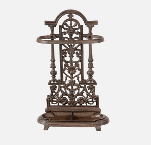 Decorative metal umbrella stand with intricate designs on a white background