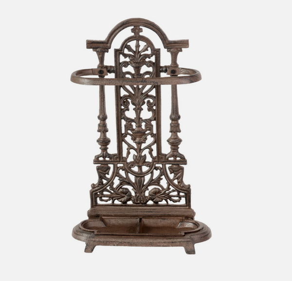 Decorative metal umbrella stand with intricate designs on a white background