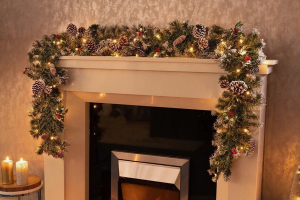Decorative Christmas garland with lights on a fireplace mantel.