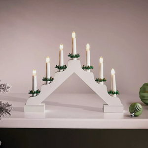 White advent candle holder with lit candles on a neutral background
