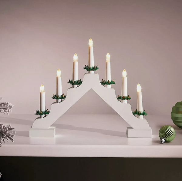 White advent candle holder with lit candles on a neutral background