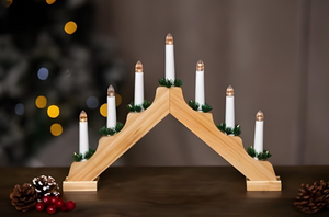 Wooden advent candle holder with white candles on a dark surface, blurred lights in the background