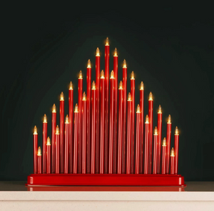 Red candle-like sculpture with gold accents on a dark background