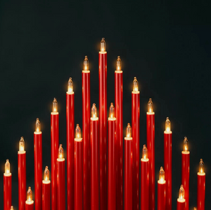 Red candles with small flames against a black background