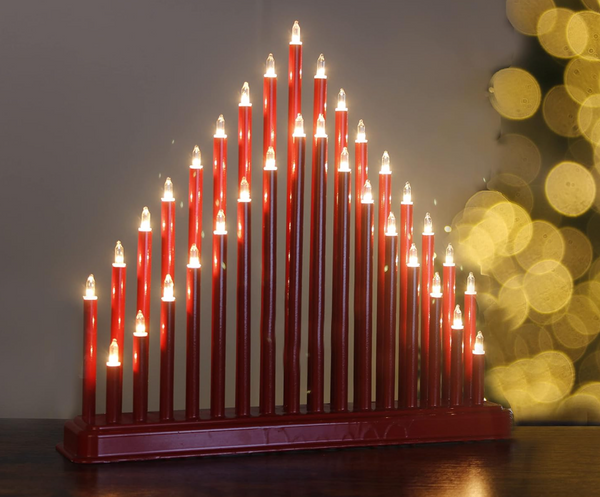 Red Hanukkah menorah with lit candles against a blurred background