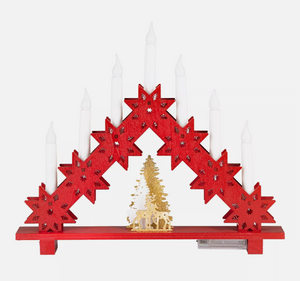 Decorative red arch with white candles and a gold tree on a white background