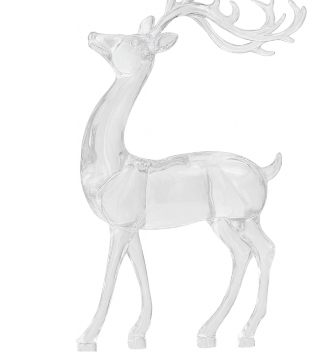 Clear glass deer ornament on a mantelpiece with a Christmas tree in the background