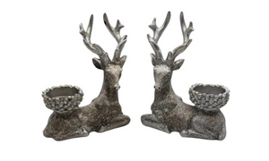 Two deer-shaped candle holders with antlers on a white background