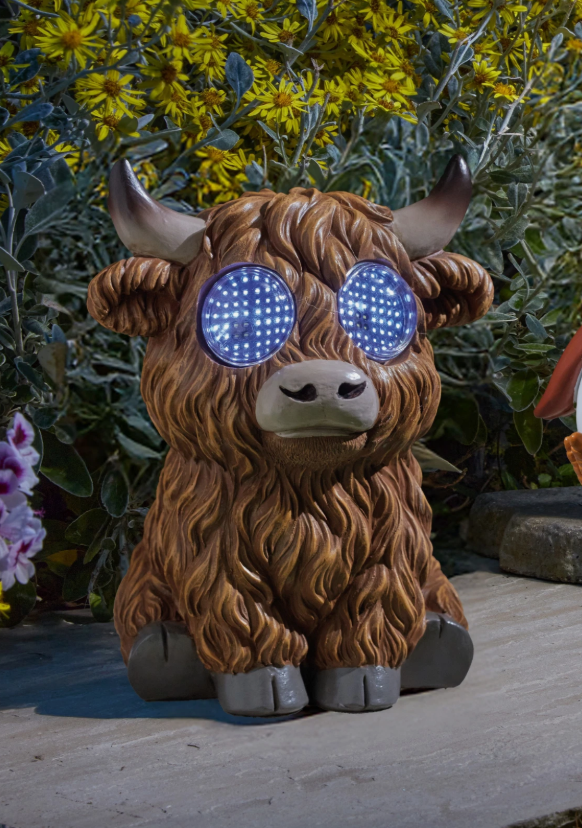 Decorative yak figurine with LED eyes in front of a natural background